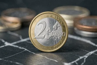 Pièce de 2 euros commémorative JO 2026 avec la Tour Eiffel en gros plan sur ardoise sombre
